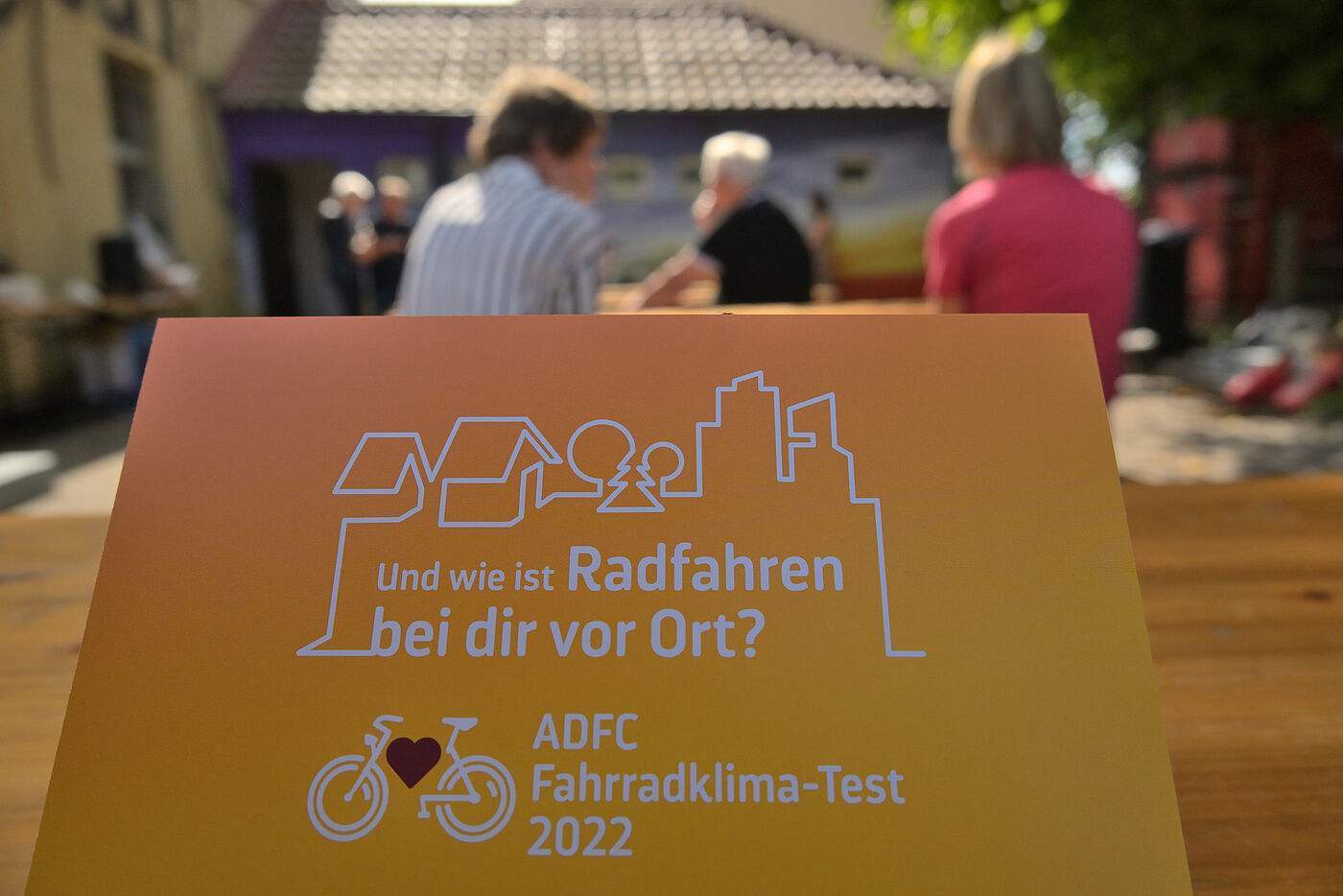 Eine Person hält die Postkarte zum Fahrradklima-Test 2022 in die Kamera